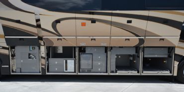 2012 Elegant Lady #7182 exterior entry side undercarriage storage bays with pull out drawers of motorcoach