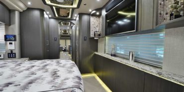 2019 Millenium #M5377 motorcoach interior view of bedroom shelving wall unit with TV
