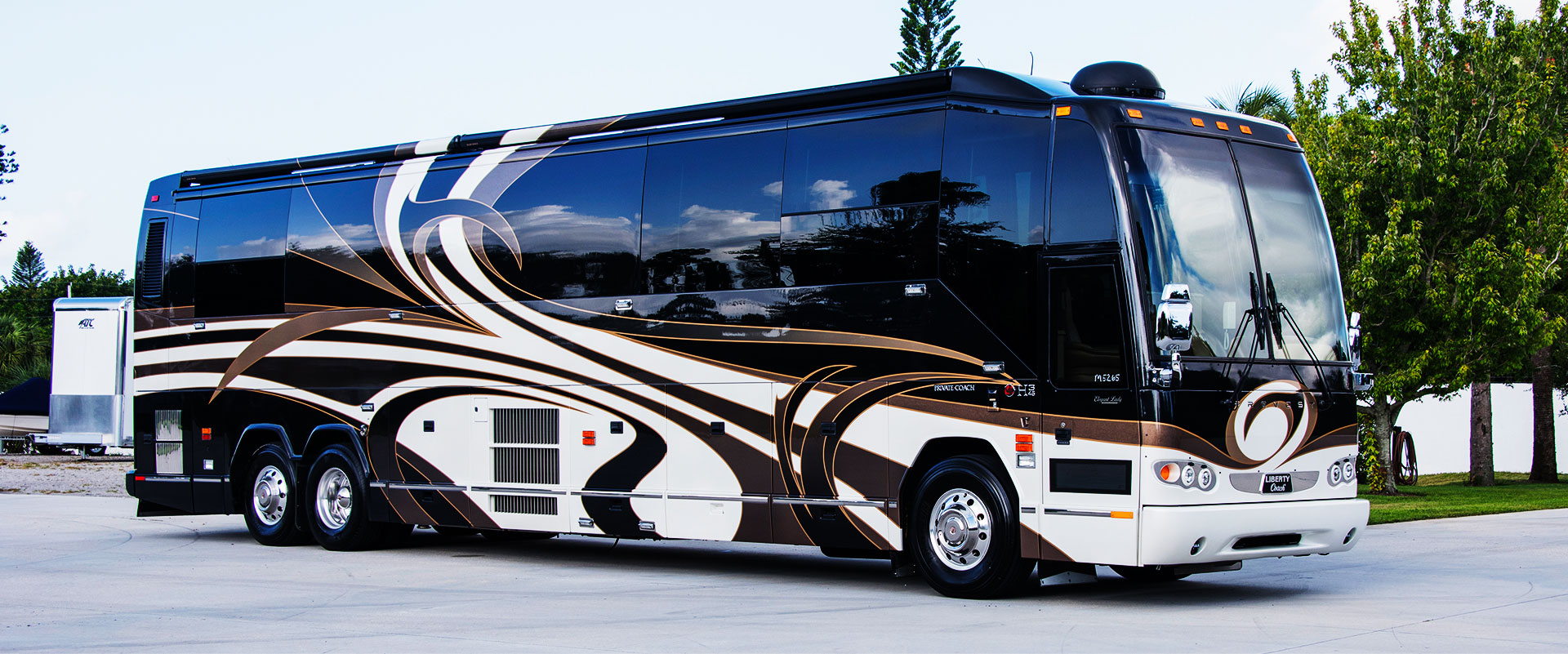 Brown and White Motorcoach parked in lot